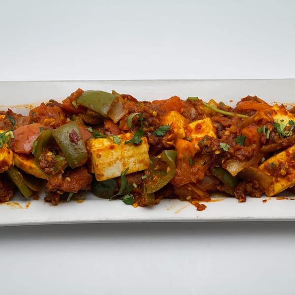Indian Palace's chili paneer, a vibrant dish with paneer, bell peppers, and spices on a white platter.